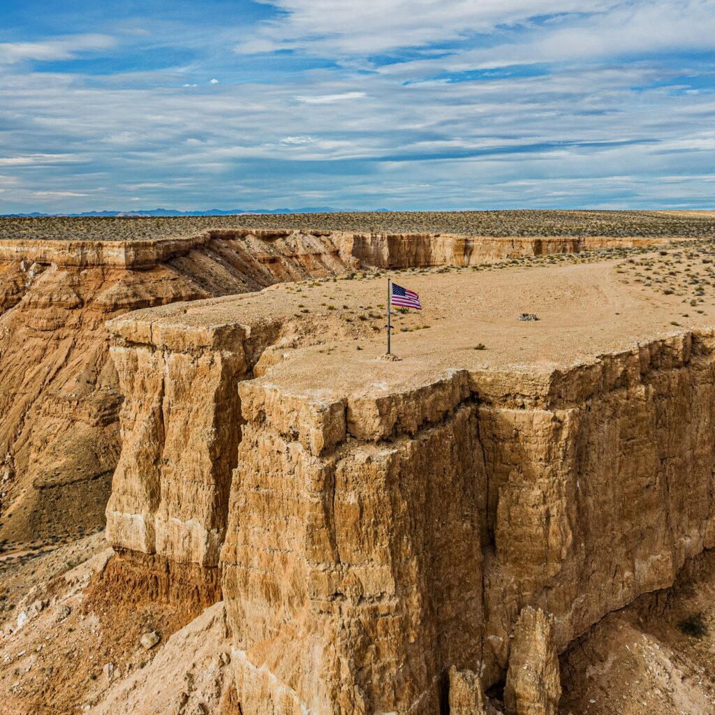 American flag on a flat-top mesa above eroded canyon walls near Mesquite, Nevada