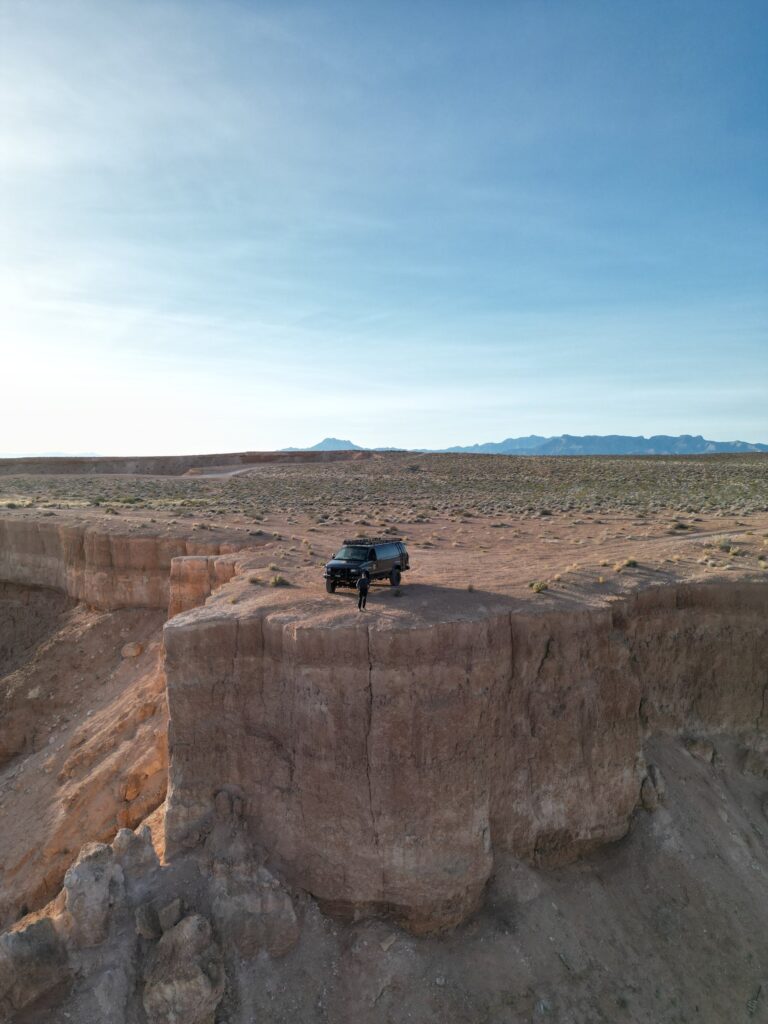 Drone view of the Mesquite Mesa Tours van on a mesa point above a canyon near Mesquite, Nevada