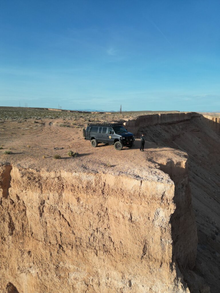 Tour van and guide on the mesa rim overlooking the canyon
