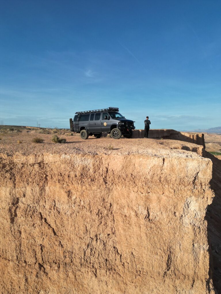Mesquite Mesa Tours van and guide at the edge of the mesa under a clear blue sky